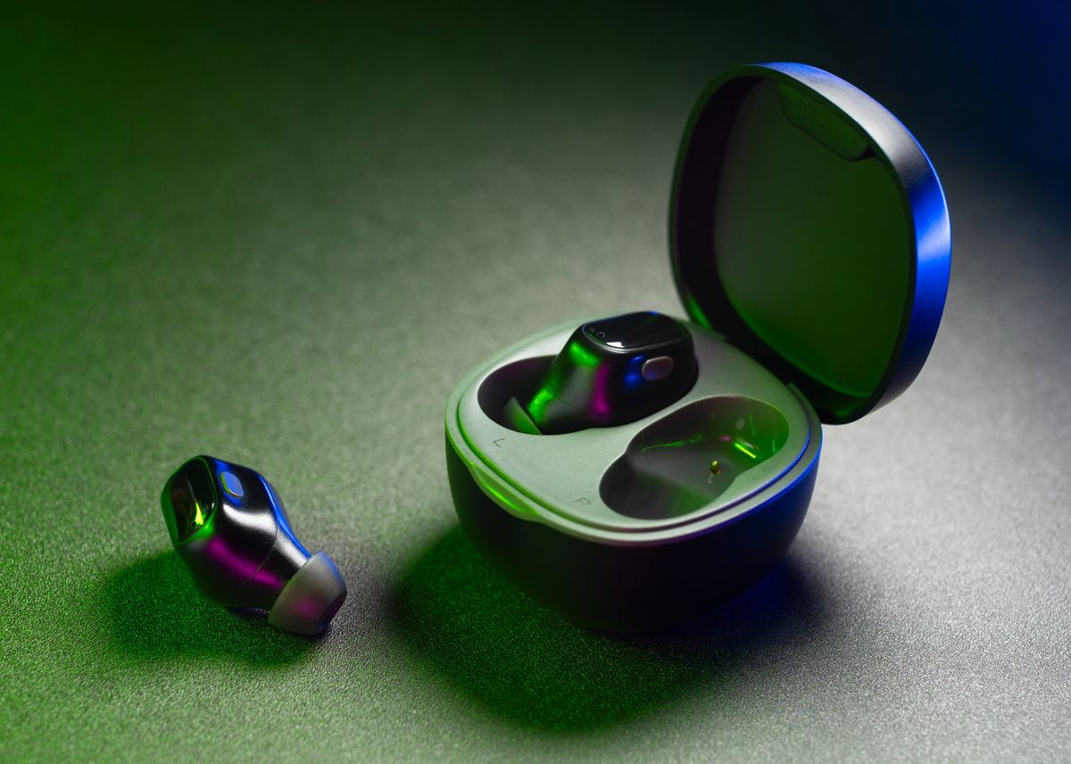 Mujer con auriculares traductores usando el ordenador