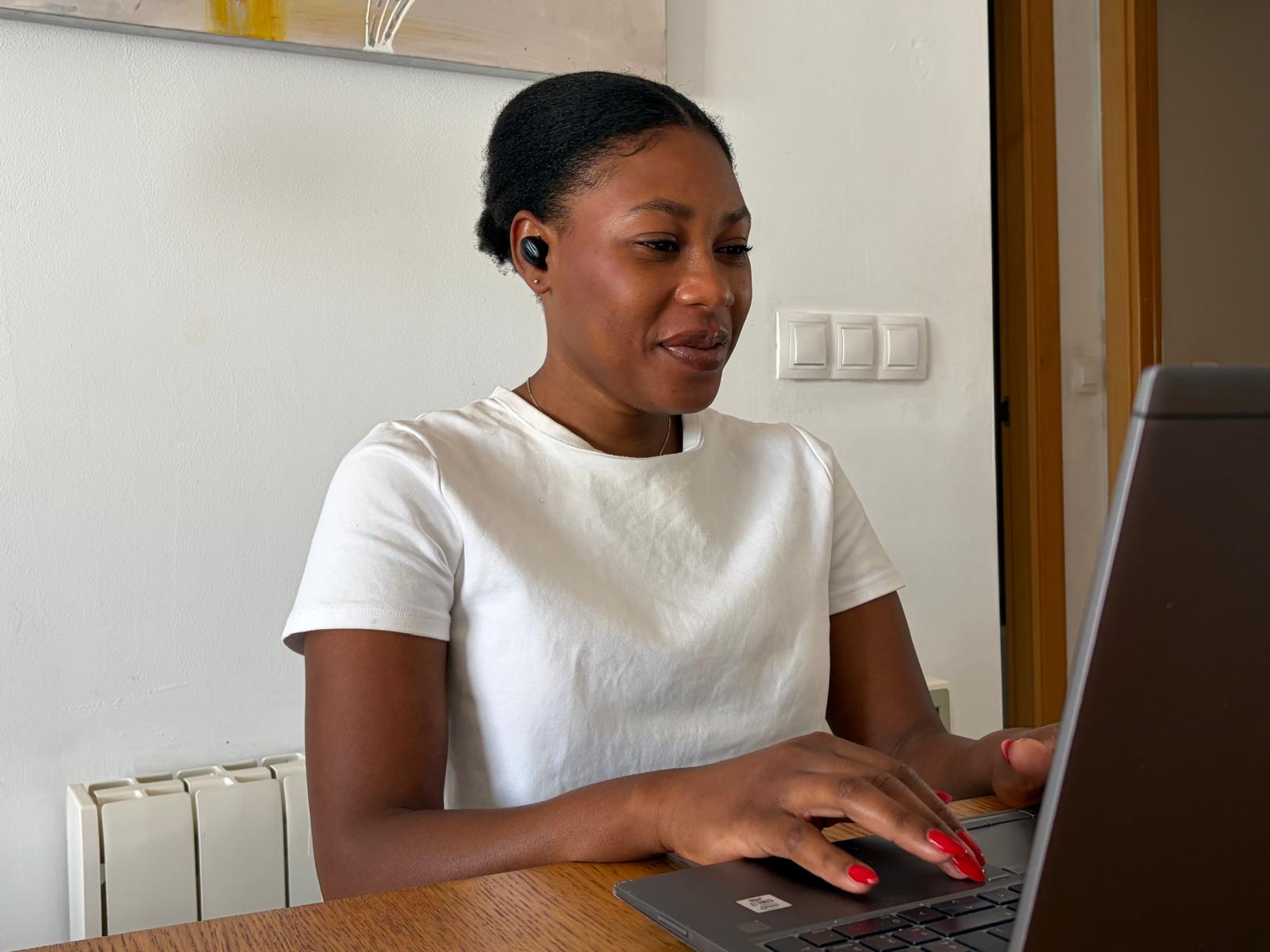 Mujer con auriculares traductores trabajando en el ordenador